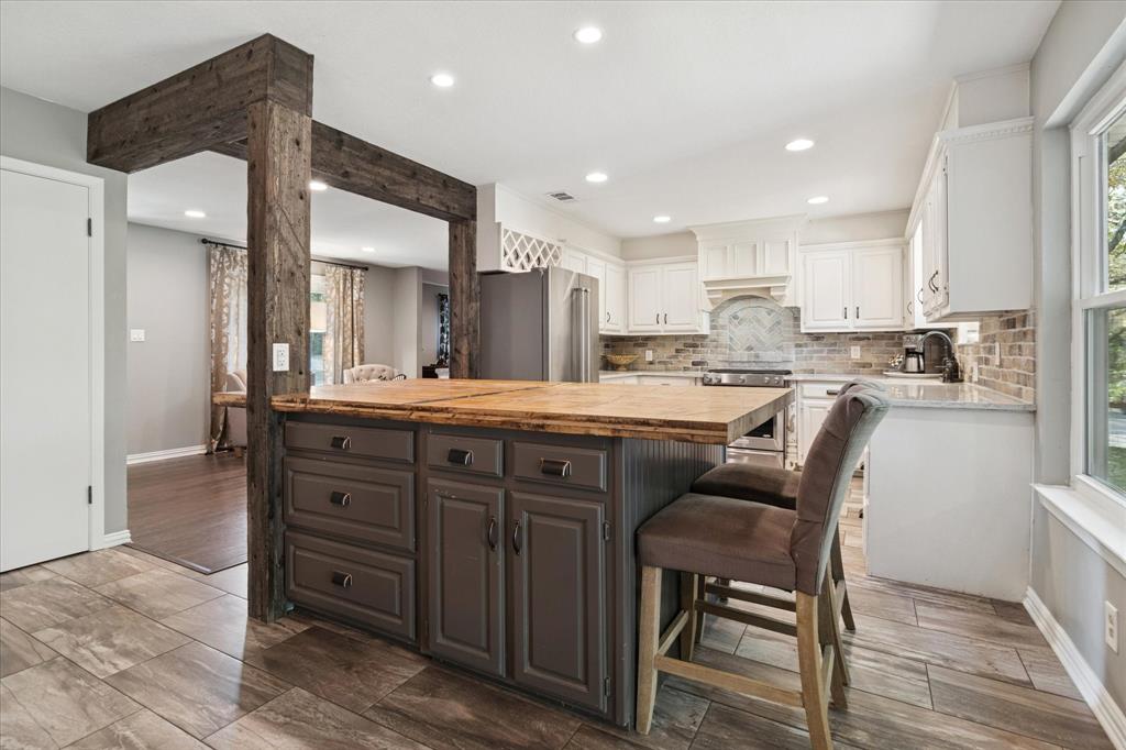 312 Old Justin Road Argyle, TX 76226 - Photo 8 of 24 a kitchen with stainless steel appliances kitchen island granite countertop a stove a sink a dining table and chairs