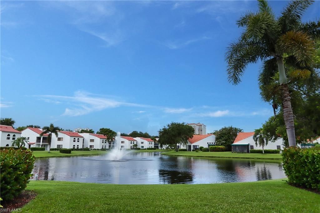 661 Windsurf Lane, Unit A103 Naples, FL 34108 - Photo 1 of 18 front view of house with yard and lake view
