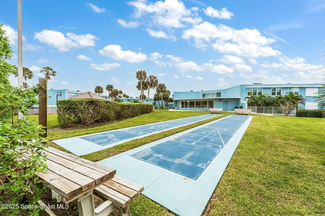 a view of a tennis ground with large trees