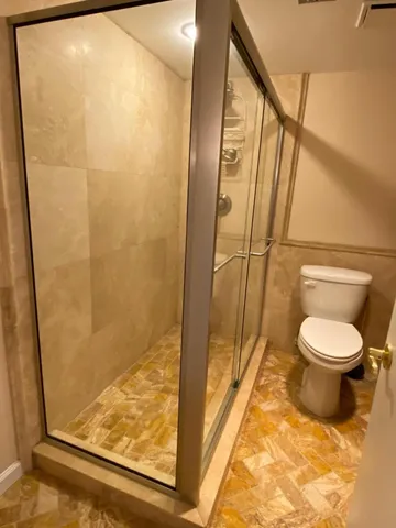 a bathroom with a toilet and a shower