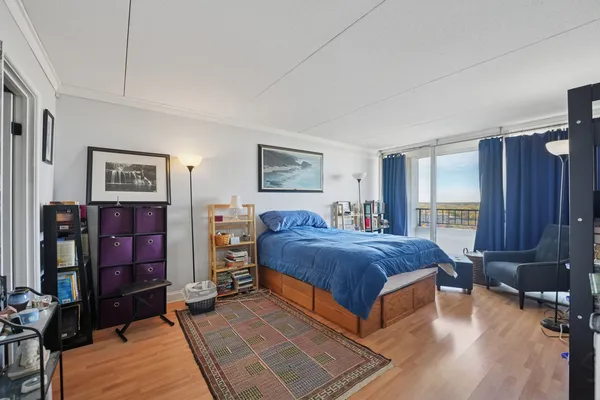 a spacious bedroom with a bed and wooden floor