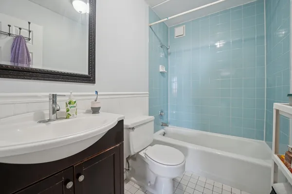 a bathroom with a sink a toilet a mirror and bathtub