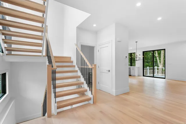 a view of a livingroom with wooden floor and stairs