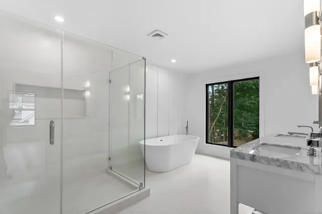a bathroom with a granite countertop sink a toilet and shower