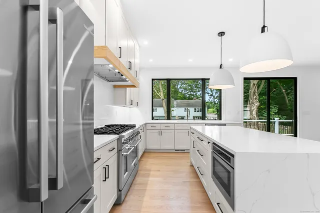 a large kitchen with stainless steel appliances granite countertop a stove and a sink