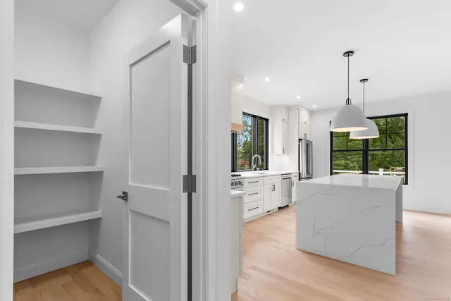 a open kitchen with white cabinets and a wooden floor