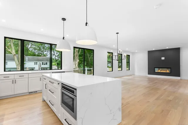 a kitchen with a stove a sink a center island and a window