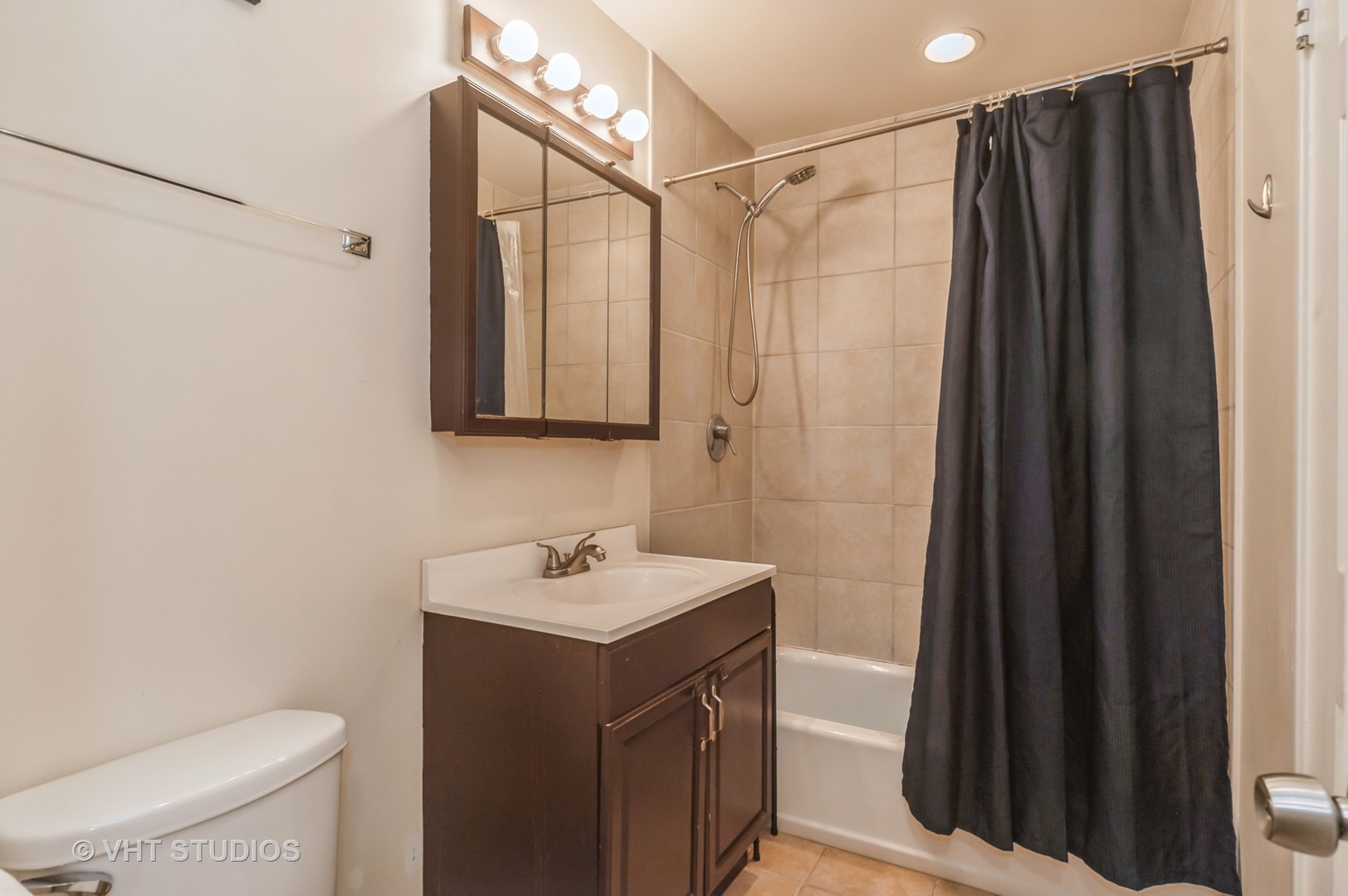 3700 Holly Lane Rolling Meadows, IL 60008 - Photo 12 of 13 a bathroom with a sink a toilet a mirror and shower curtain