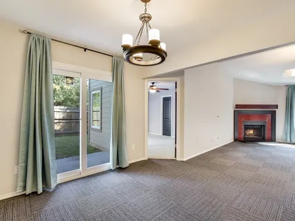 a view of a livingroom with a chandelier fireplace and window