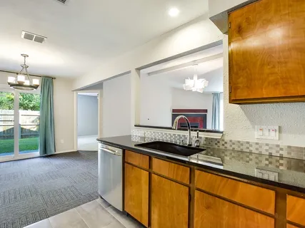 a kitchen with granite countertop a sink and a wooden cabinets