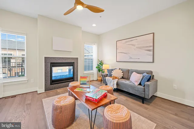 a living room with furniture a fireplace a flat screen tv and a window
