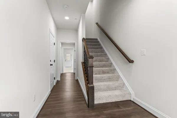 a view of a hallway with wooden floor and entryway