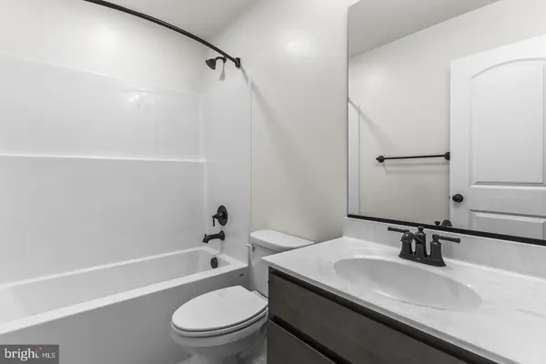 a bathroom with a granite countertop sink toilet a mirror and shower