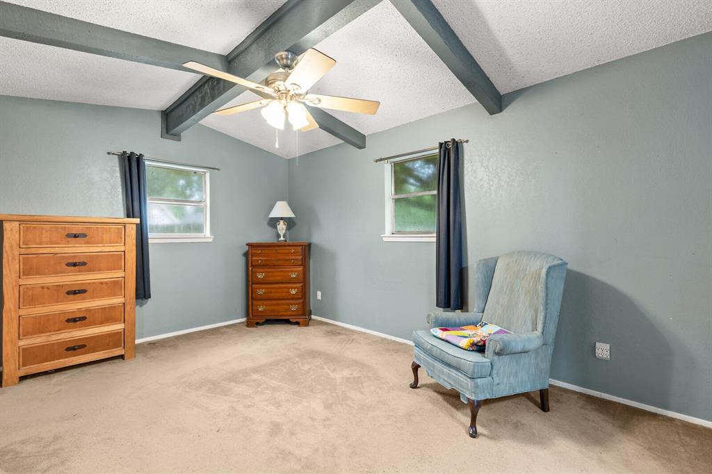 505 Pinewood Lane Hewitt, TX 76643 - Photo 19 of 38 Room featuring a vaulted ceiling with exposed beams, a ceiling fan, and carpeted flooring