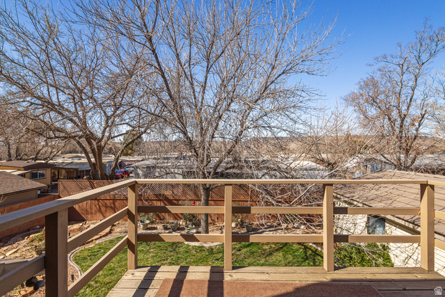 892 Cambridge Drive St. George, UT 84770 - Photo 54 of 65 Elevated wood deck with a matching wood railing, overlooking a fenced backyard with green lawn