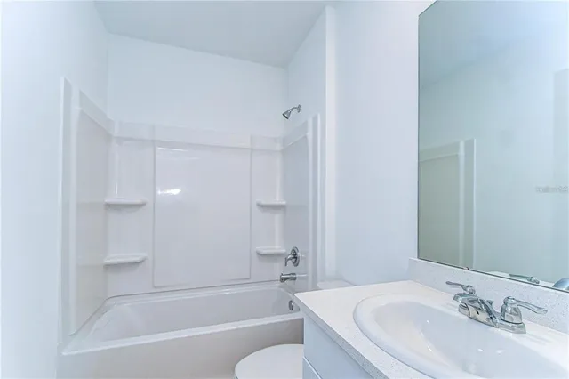 a bathroom with a bathtub shower sink vanity and a toilet