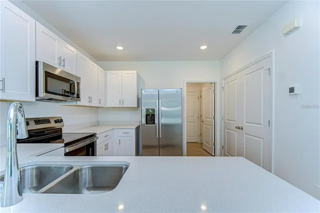 a kitchen with stainless steel appliances a refrigerator sink and microwave