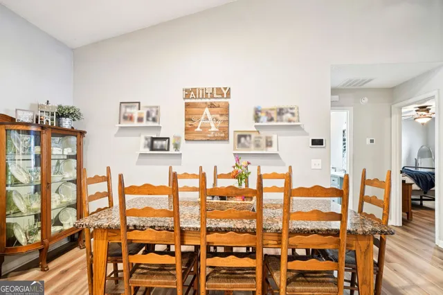 a kitchen with stainless steel appliances granite countertop a stove top oven a sink dishwasher and a refrigerator with wooden floor