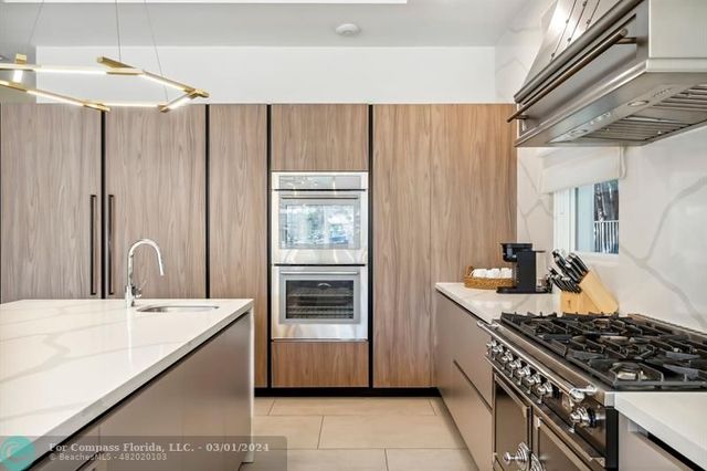 a kitchen with kitchen island granite countertop a sink stove and refrigerator