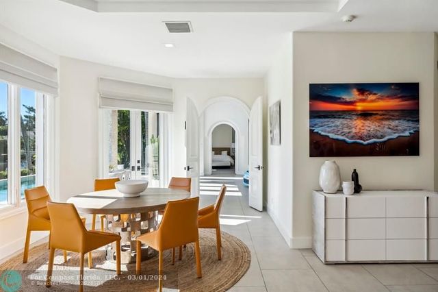 a view of a dining room with furniture a rug and a flat screen tv