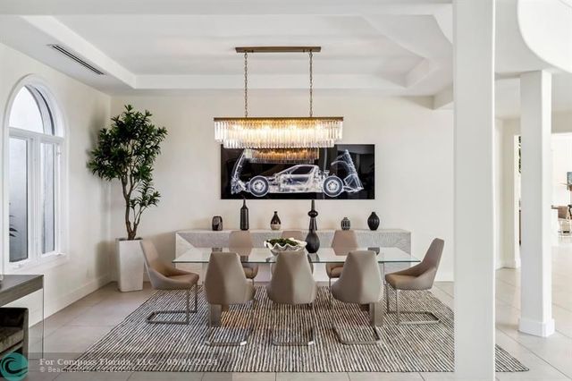 a dining room with furniture a rug and a chandelier