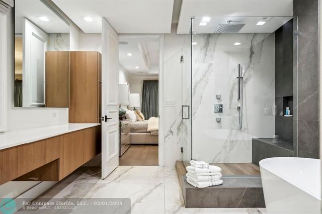 a large bathroom with a glass shower door and a bathtub