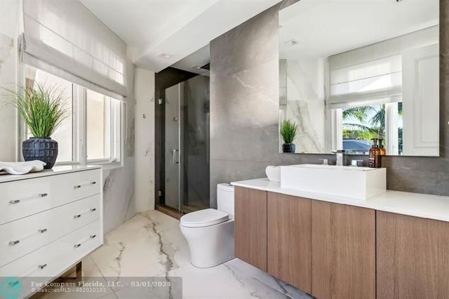 a spacious bathroom with a granite countertop sink a toilet a mirror and a tub