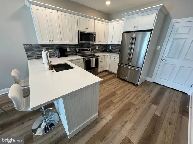 a kitchen with a refrigerator a stove top oven a sink and dishwasher