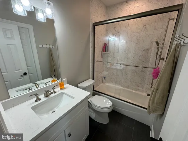 a bathroom with a sink mirror toilet and shower