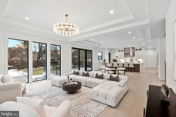 a living room with furniture chandelier and a large window