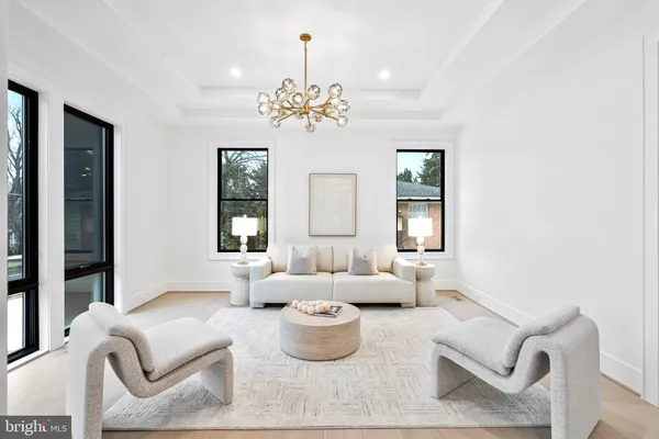 a large kitchen with kitchen island a dining table chairs and white cabinets