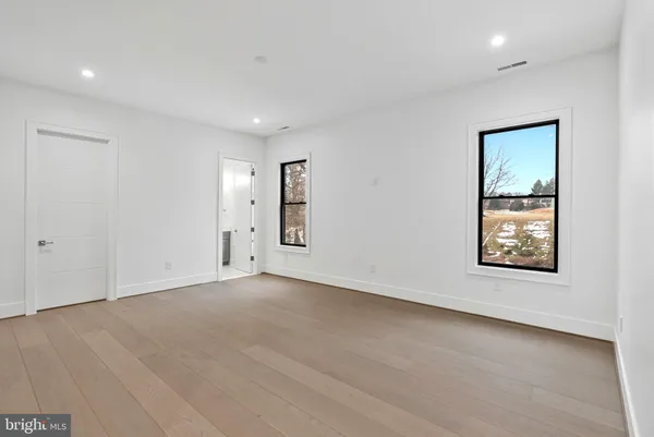 a spacious bathroom with a double vanity sink a large mirror and a bathtub