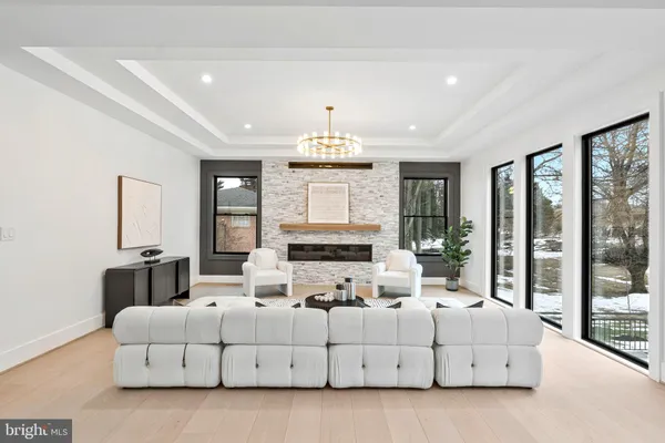 a living room with furniture chandelier and a large window