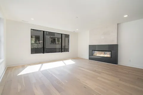 a view of an empty room with a window and fireplace
