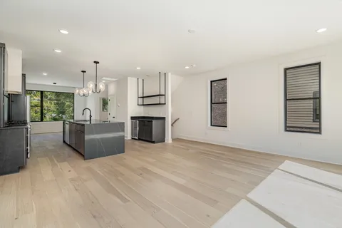 a view of open kitchen with kitchen island wooden cabinets and refrigerator
