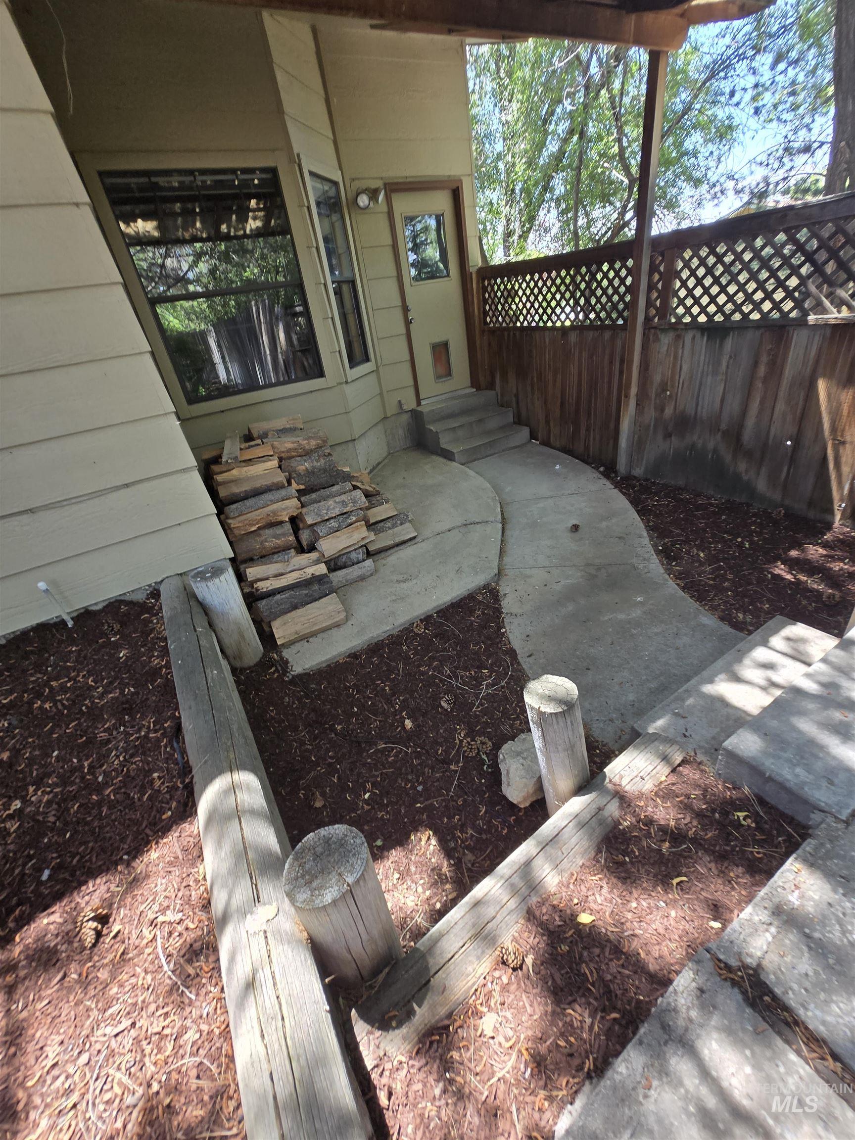 12050 West Hidden Valley Rim Road Boise, ID 83709 - Photo 37 of 39 Concrete pathway leading to a side entry door with a multi-pane window
