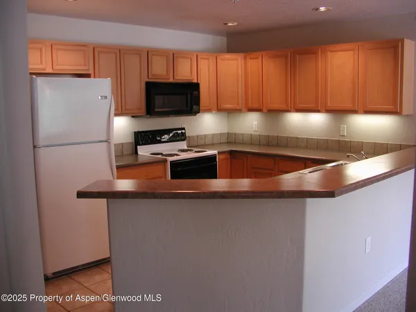 a kitchen with stainless steel appliances granite countertop a sink a stove and a refrigerator