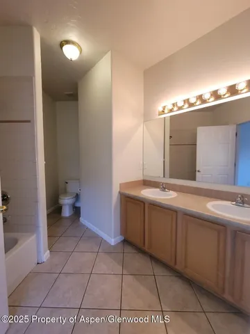 a bathroom with a tub a sink and mirror