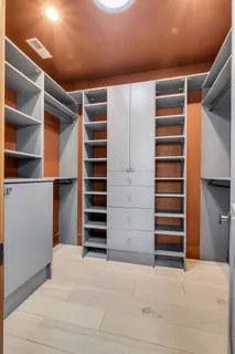 a view of walk in closet with clothes and shoes