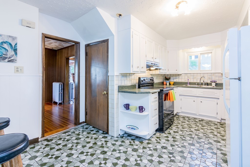 55 Crown Street Springfield, MA 01108 - Photo 5 of 30 a kitchen with a stove a sink and a refrigerator