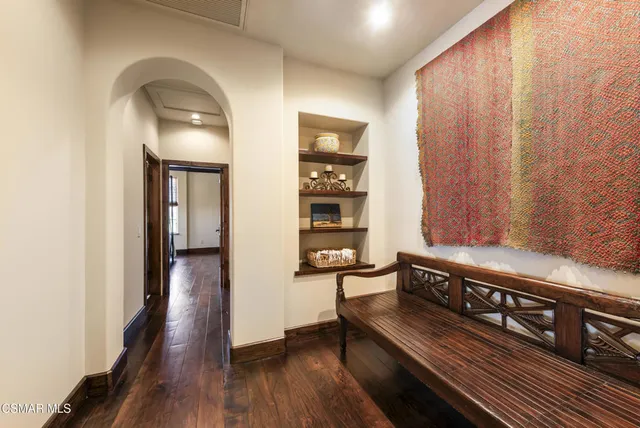 a bedroom with a bed and a dresser with wooden floor