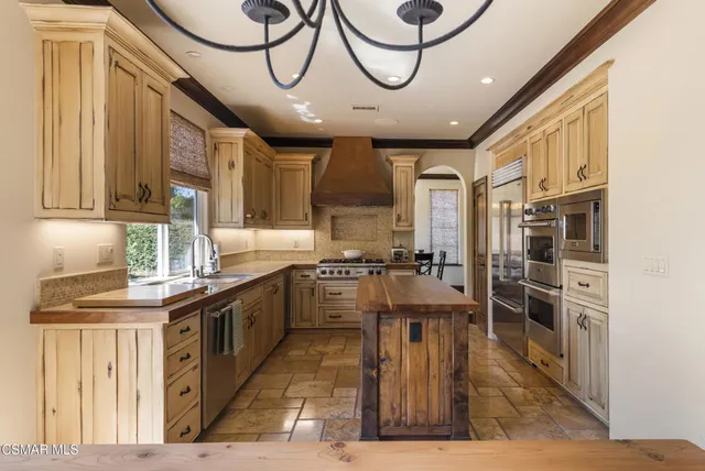 a kitchen with stainless steel appliances granite countertop a stove and cabinets