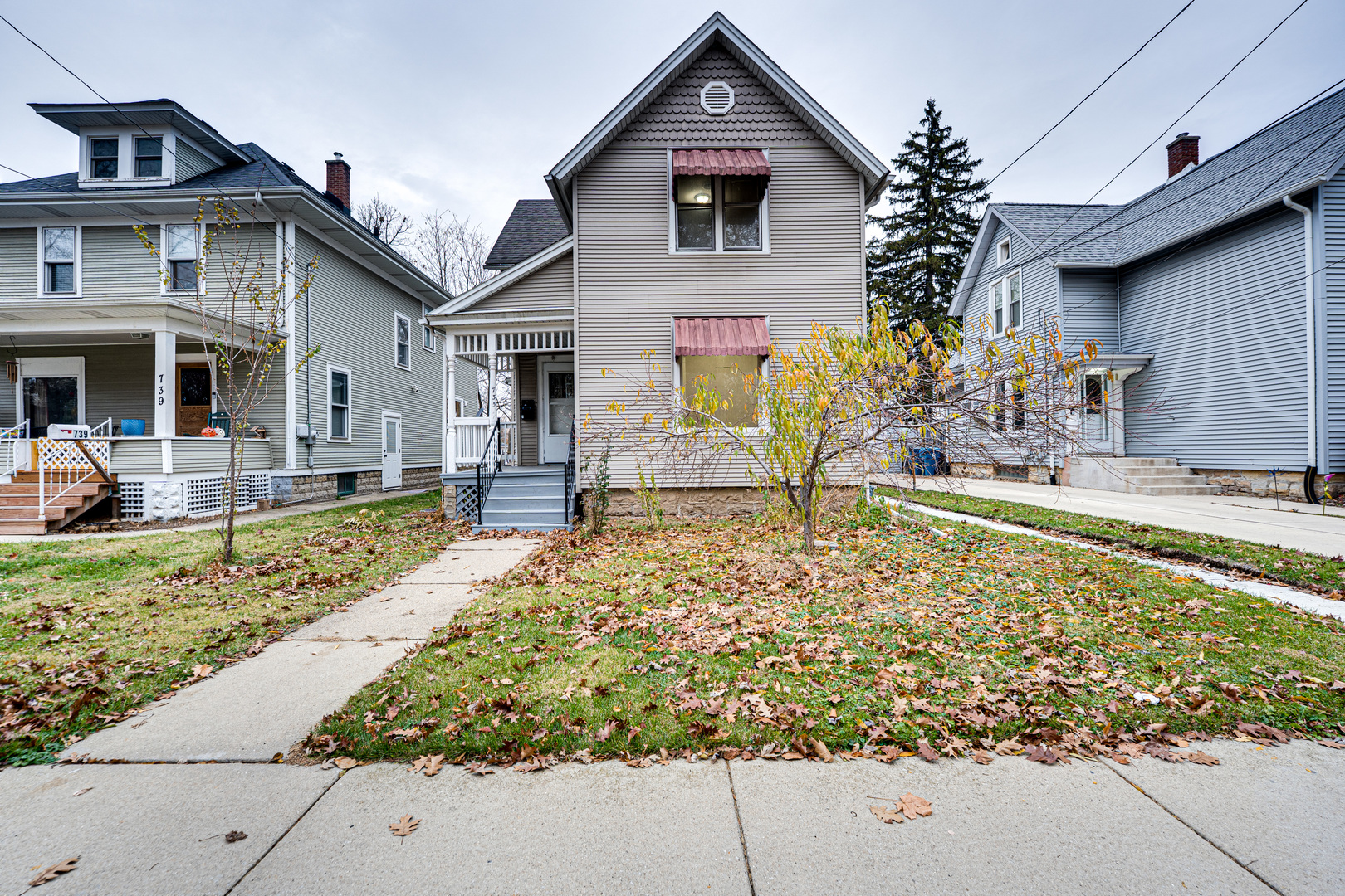 a front view of house with small garden and palm trees