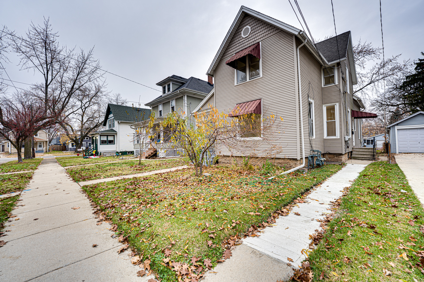 735 Sexton Street, Unit 2 Aurora, IL 60505 - Photo 2 of 18 a view of a white house with large windows and a small yard