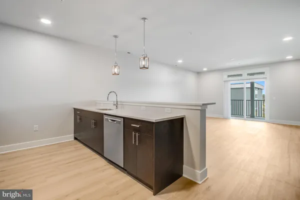 a kitchen with stainless steel appliances granite countertop a sink and dishwasher with wooden floor