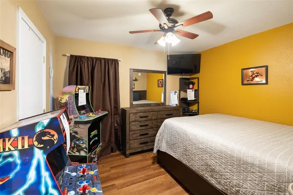 a bedroom with bed dresser and a window