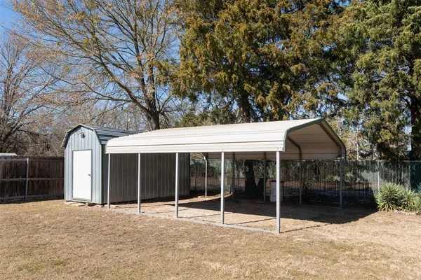 a view of a house with a yard and large tree