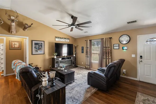 a living room with furniture a flat screen tv and a window