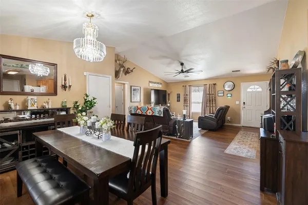 a view of a dining room with furniture a chandelier and wooden floor