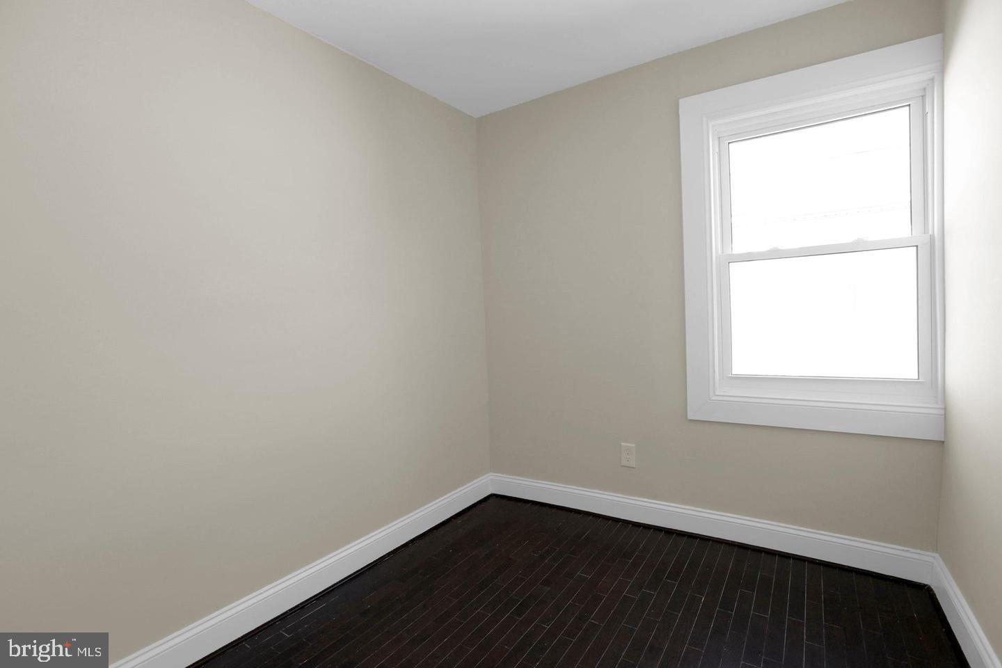 203 Sollers Point Road Dundalk, MD 21222 - Photo 11 of 14 a view of an empty room with wooden floor and a window